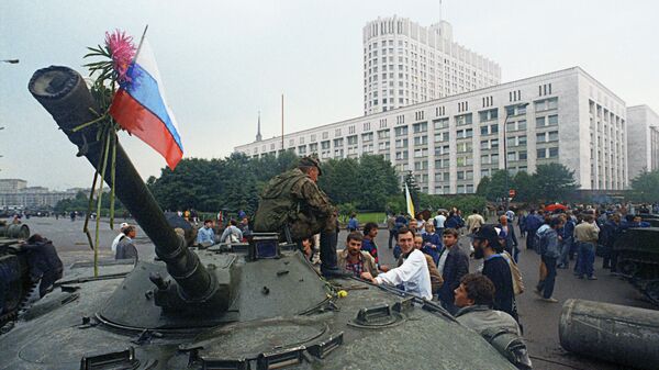 Защитники Белого дома прикрепили цветы к орудийному стволу одного из танков, введенных в Москву 19 августа 1991 года в связи с объявлением членами ГКЧП чрезвычайного положения в столице - Sputnik Latvija