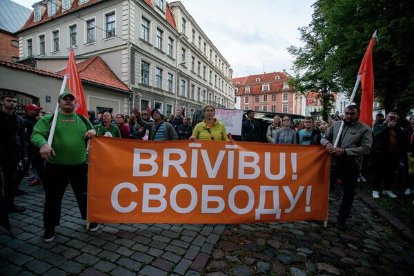 Участники митинга пришли на акцию с плакатами, требуя свободы выбора в вопросе вакцинации против COVID-19 - Sputnik Латвия