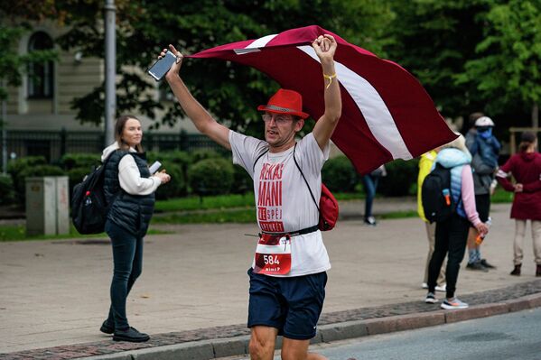 Участник Рижского марафона пробежал всю дистанцию с латвийским флагом - Sputnik Латвия