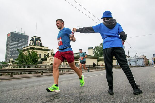 Спортсмен берет бутылку воды на дистанции марафона - Sputnik Латвия