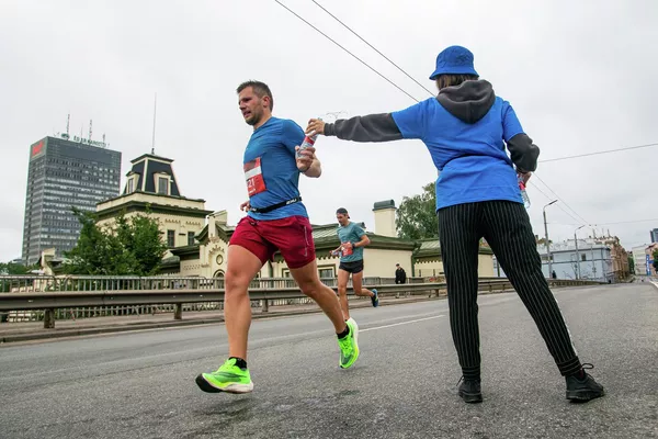 Спортсмен берет бутылку воды на дистанции марафона Спортсмен берет бутылку воды на дистанции марафона - Sputnik Латвия