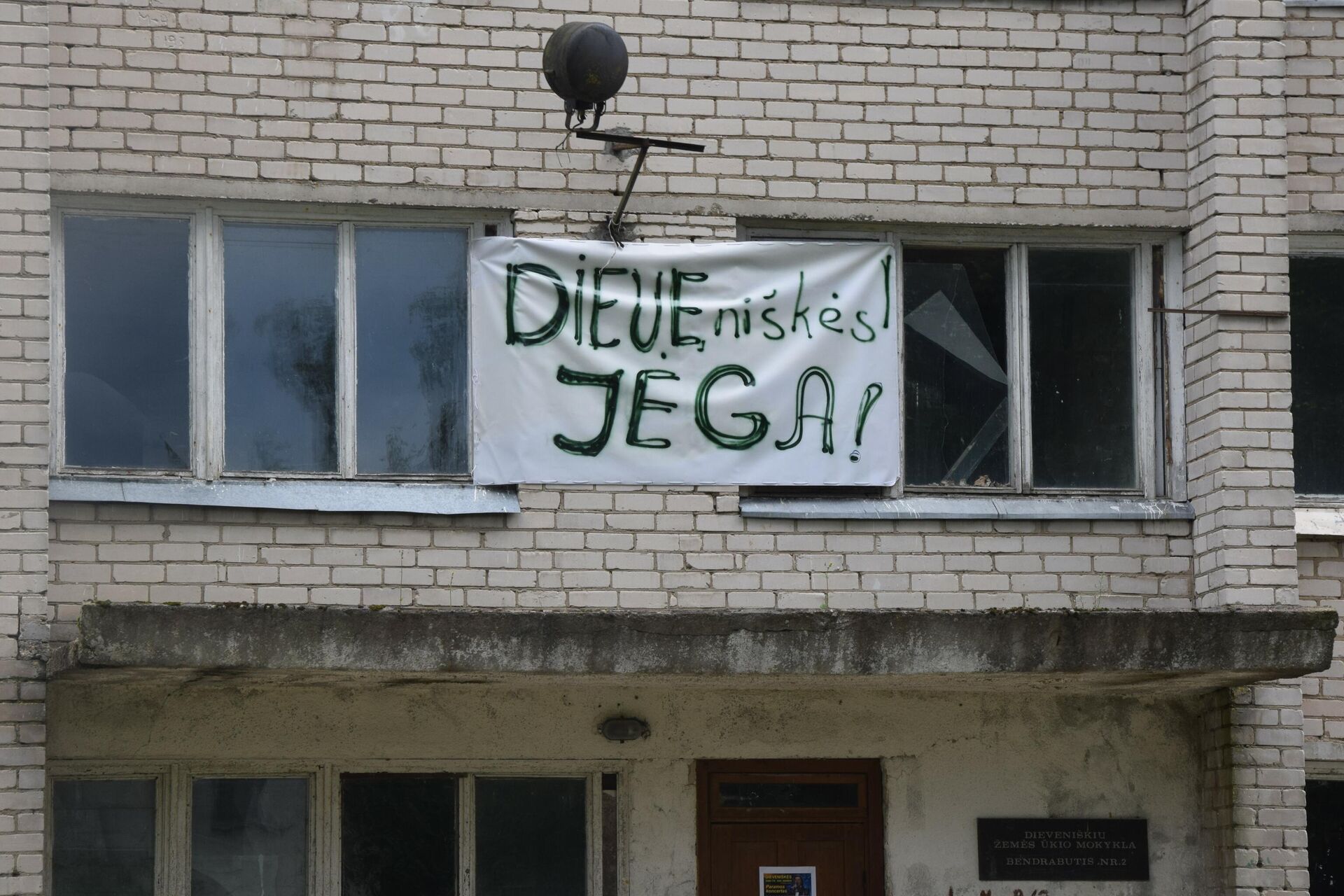 Плакат Девенишкес – сила на здании в деревне Девенишкес в Литве - Sputnik Латвия, 1920, 30.08.2021