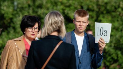 Старшеклассник держит табличку с названием своего класса