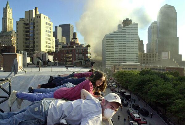 Жители наблюдают с крыши здания на Гринвич-стрит в Нью-Йорке за спасательными работами внизу. - Sputnik Латвия