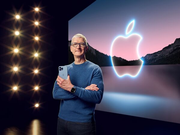 Тим Кук держит iPhone 13 Pro Max и надел Apple Watch Series 7 во время презентации в Купертино - Sputnik Латвия