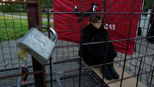 Волонтер Валерия сидит в клетке, протестуя против пушного звероводства в Латвии - Sputnik Латвия