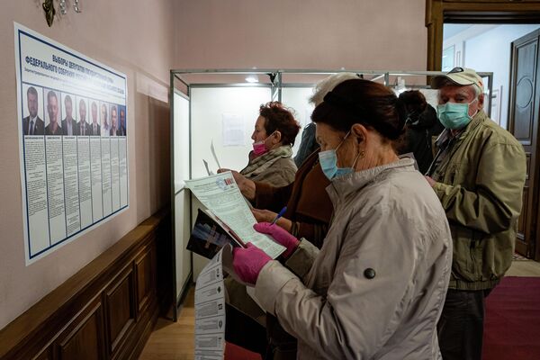 Люди внимательно изучают информацию о выборах. - Sputnik Латвия