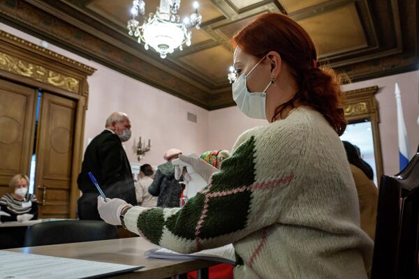Члены избирательной комиссии в масках и перчатках. - Sputnik Латвия