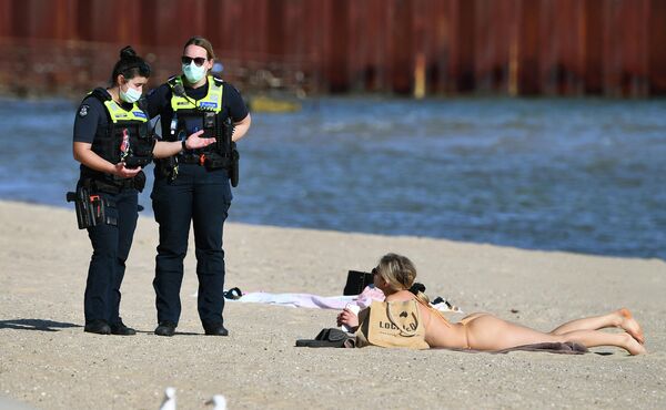 Policisti sarunājas ar meiteni, kas atpūšas pludmalē Melburnā - Sputnik Latvija