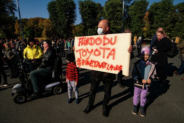Мужчина с плакатом &quot;Продаю Toyota&quot; на митинге протеста у памятника Свободы - Sputnik Латвия