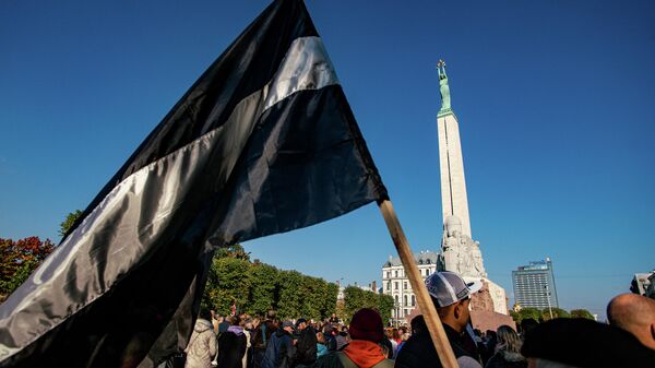 Латвийский флаг в черно-белом исполнении на митинге протеста у памятника Свободы - Sputnik Латвия
