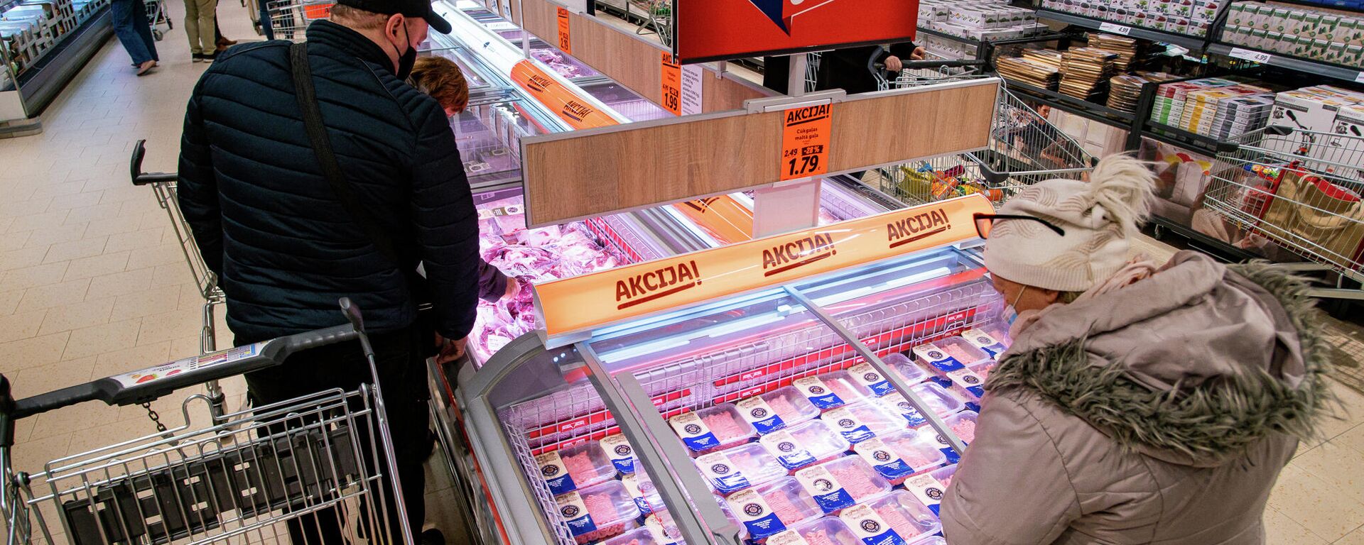 Посетители магазина Lidl изучают акционные товары - Sputnik Латвия, 1920, 30.11.2025
