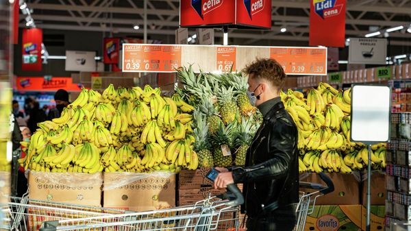 Покупатель проходит у  стенда со знаменитыми бананами, ставшими символом прихода сети Lidl в Латвию - Sputnik Латвия