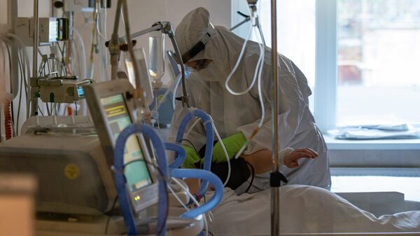 Медицинский работник у кровати пациента с COVID-19 в Центре легочных заболеваний и туберкулеза в Даугавпилсе - Sputnik Латвия