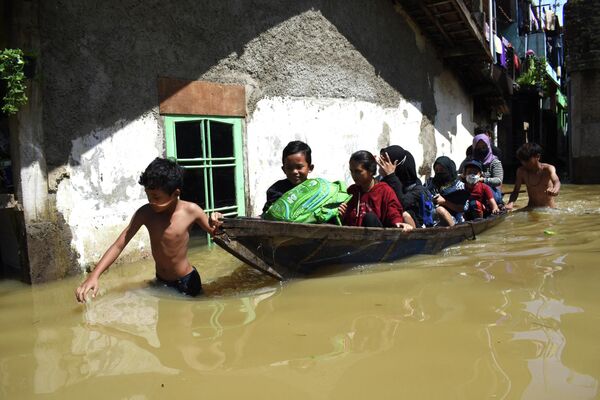 Ģimene evakuējas no pārplūdušas mājas pēc lietavām Indonēzijā - Sputnik Latvija