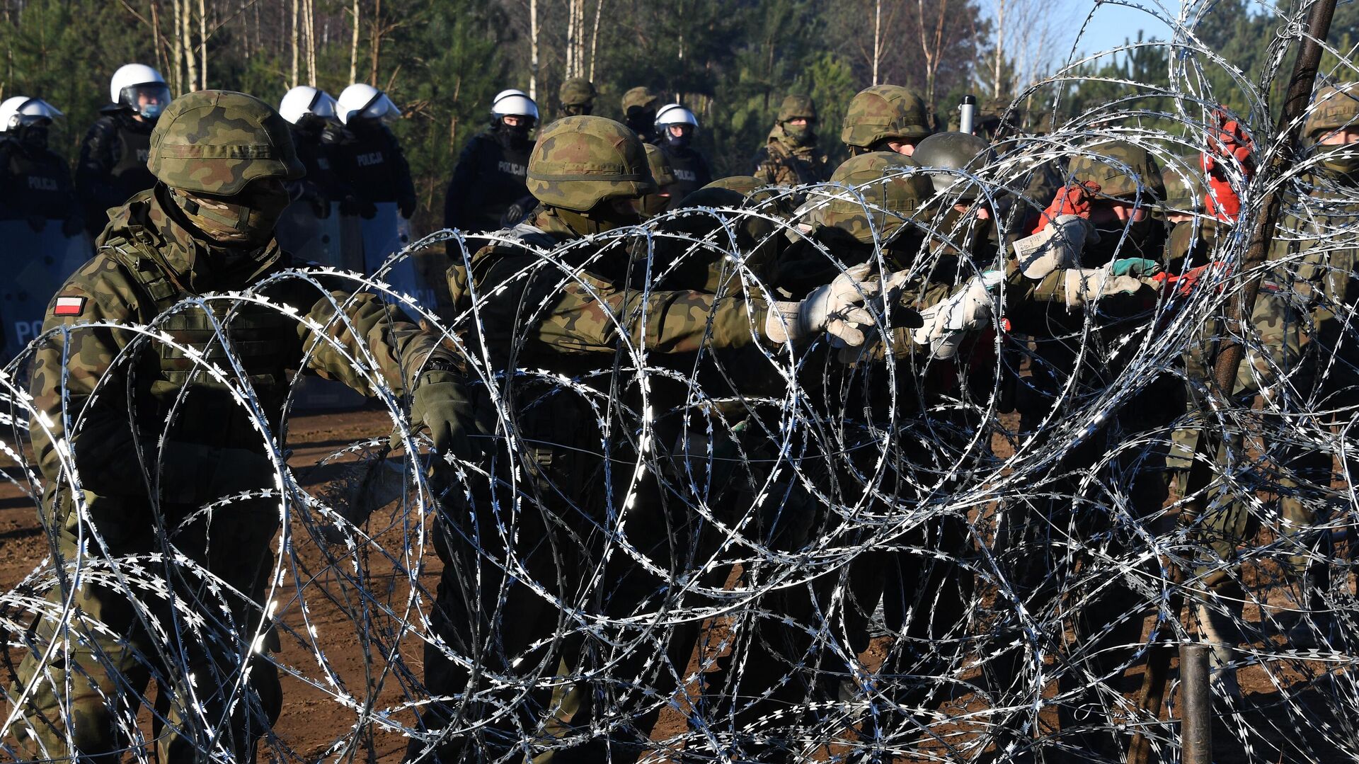 Польские военнослужащие устанавливают забор из колючей проволоки на польско-белорусской границе - Sputnik Латвия, 1920, 26.11.2021