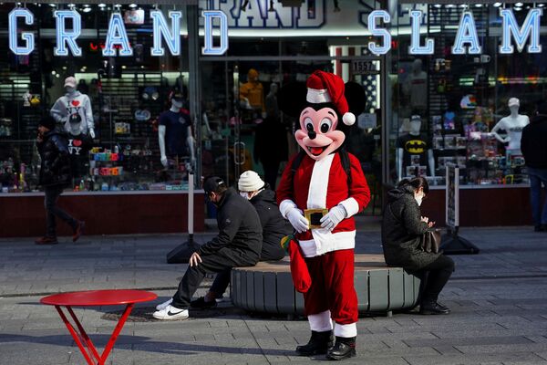 Микки Маус в костюме Санты позирует для фотографий на Таймс-сквер в Нью-Йорке. - Sputnik Латвия