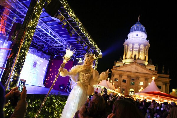 Актер в костюме Снежной королевы встречает людей на площади Жандарменмаркт в центре Берлина. - Sputnik Латвия