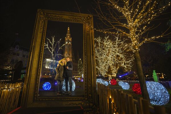 Пара позирует на фоне здания мэрии на рождественской ярмарке в Вене. - Sputnik Латвия
