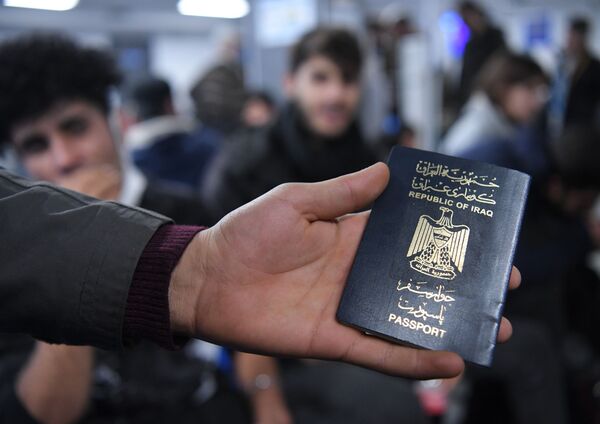 Иракский паспорт в руке одного из беженцев. - Sputnik Латвия