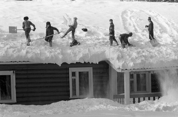 Sniegota ziema Komi APSR. Zēni tīra sniegu no mājas jumta Siktivkarā, 1988. gads - Sputnik Latvija