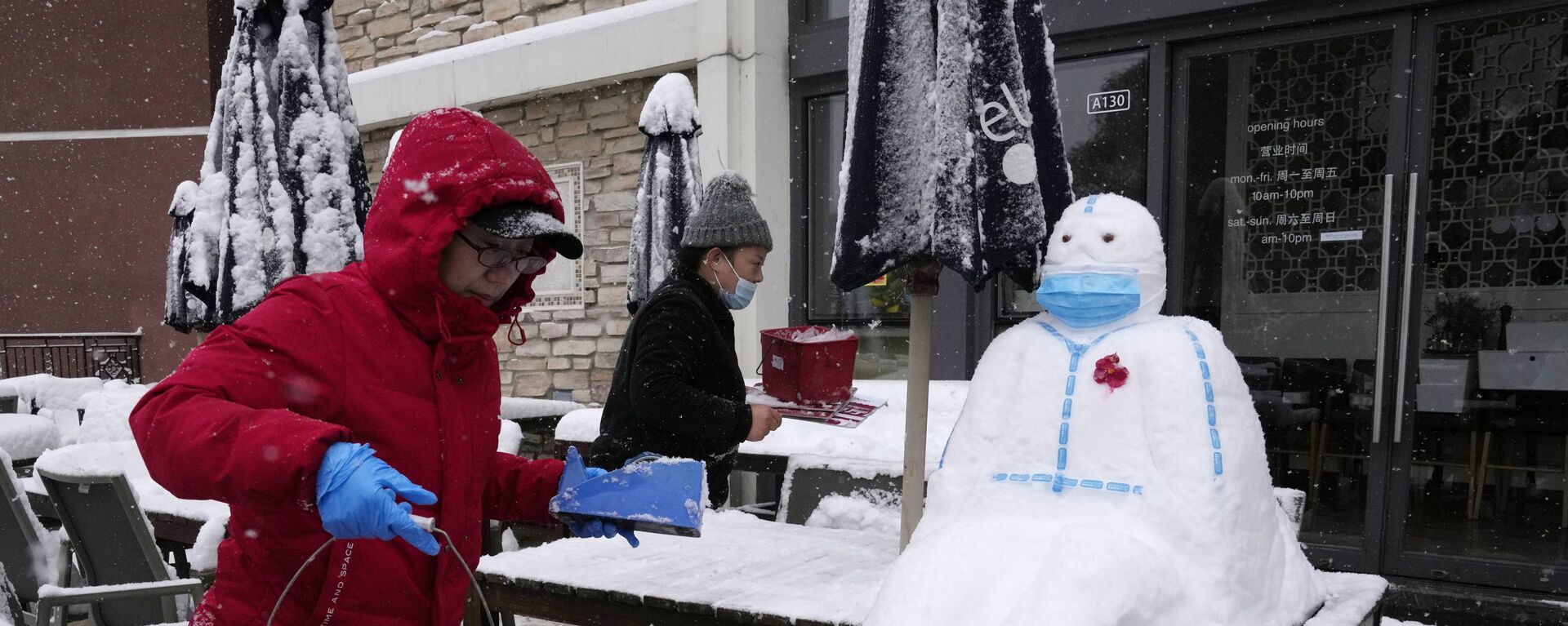 Работники ресторане лепят снеговика в форме медицинского работника в защитном костюме и маске в Пекине, Китай - Sputnik Латвия, 1920, 04.02.2022