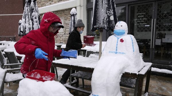 Работники ресторане лепят снеговика в форме медицинского работника в защитном костюме и маске в Пекине, Китай - Sputnik Латвия