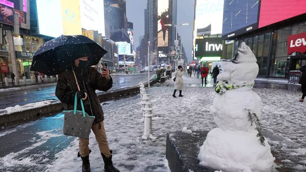 Мужчина фотографирует снеговика на Таймс-сквер в Нью-Йорке, США - Sputnik Латвия