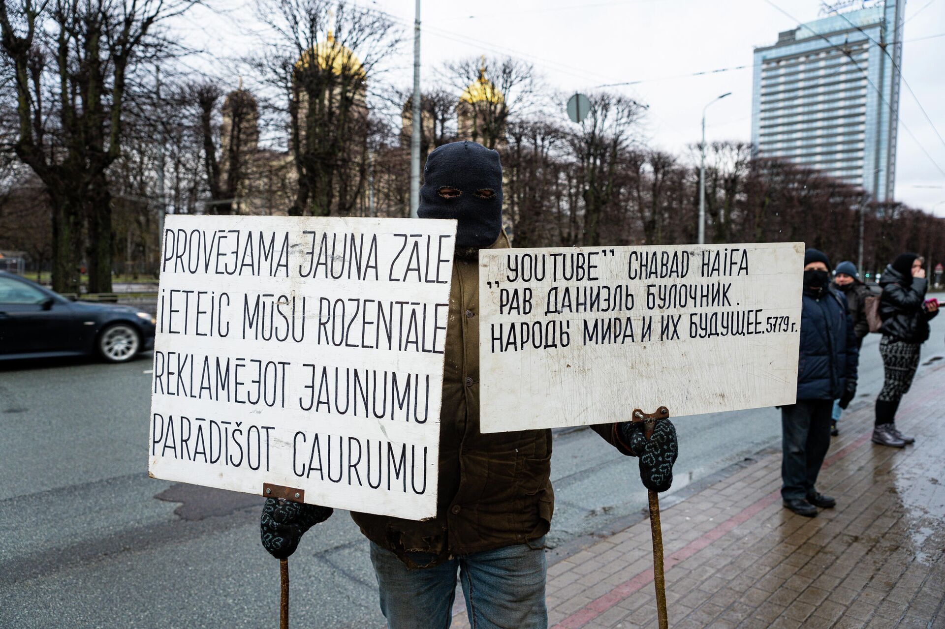 Протестующий с плакатами на открытии памятника Гунару Астре - Sputnik Латвия, 1920, 20.01.2022