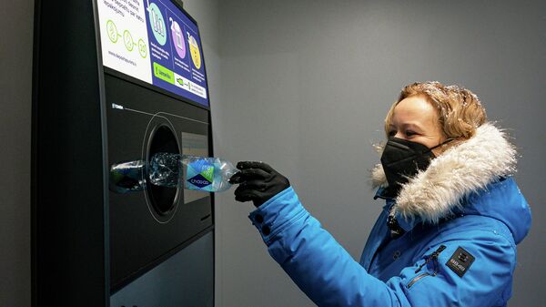 Девушка сдает пустую бутылку в автомат латвийской системы депозитной тары - Sputnik Латвия