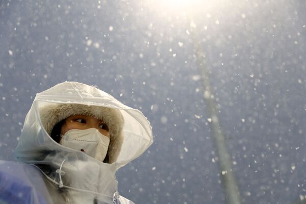 Олимпийский чиновник под снегопадом наблюдает за Играми. - Sputnik Латвия
