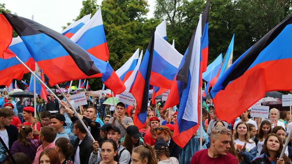 Люди с флагами РФ и непризнанной ДНР в Донецке - Sputnik Латвия