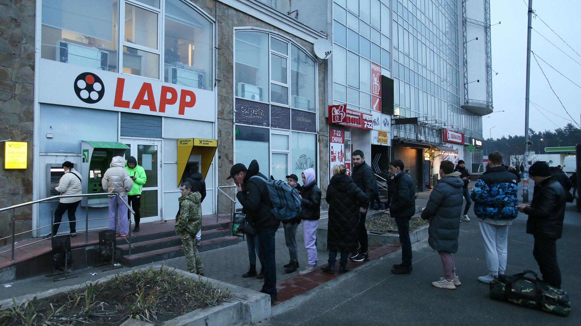 Люди стоят в очереди для того чтобы снять денежные средства в банкомате на одной из улиц в Киеве - Sputnik Латвия, 1920, 24.02.2022