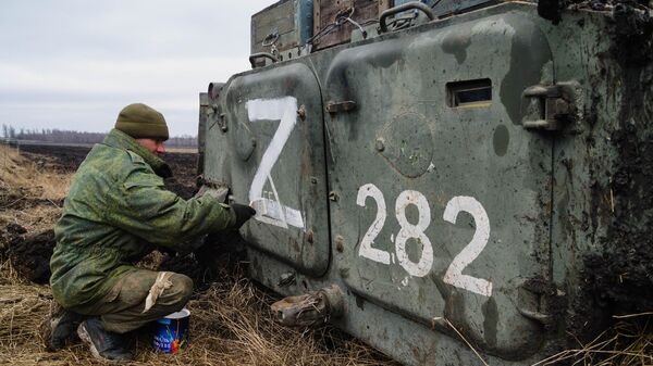 Военнослужащий народной милиции ДНР наносит знак Z на бронетехнику под Волновахой - Sputnik Latvija