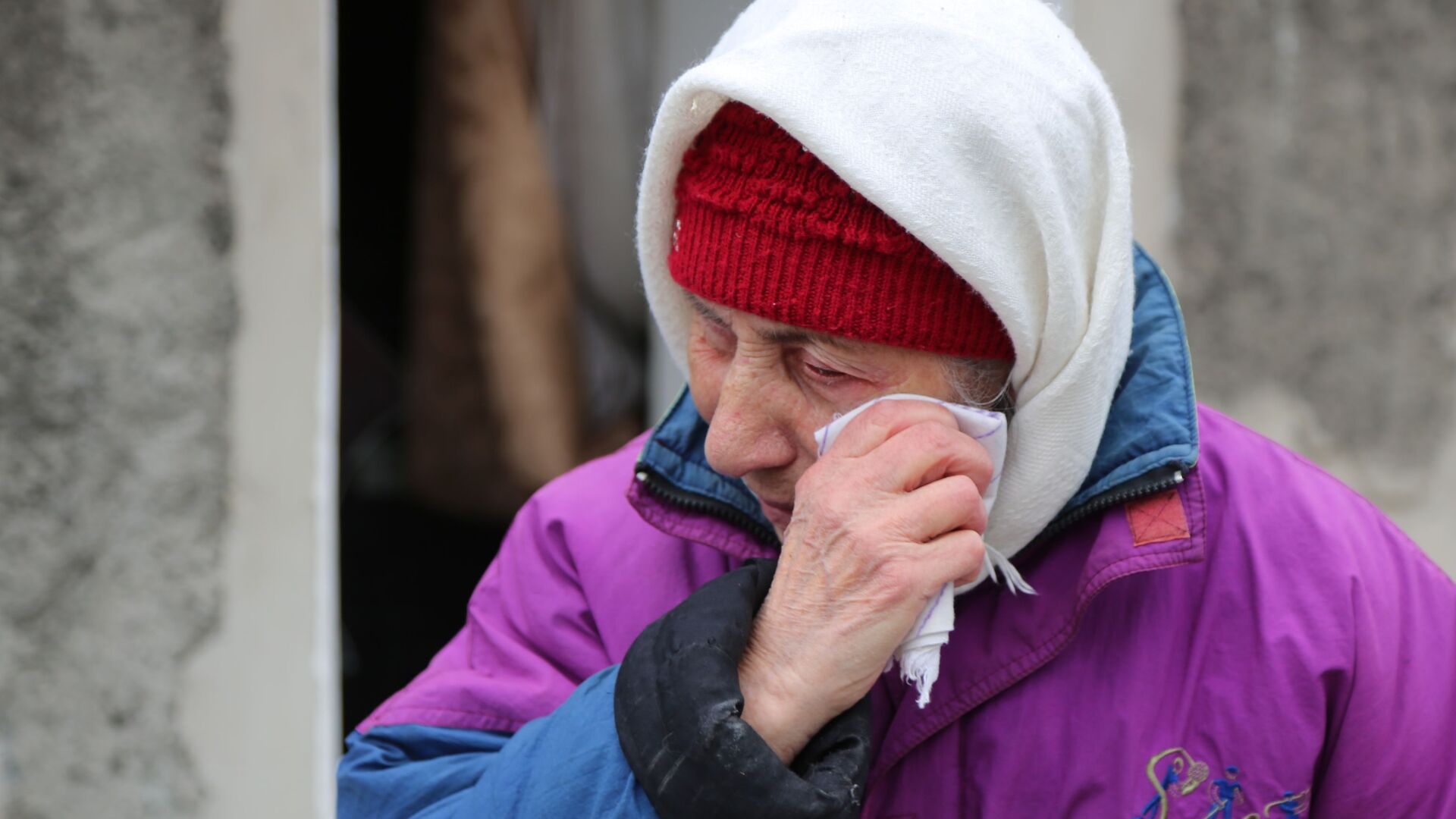 Пожилая женщина плачет около жилого дома в Киевском районе Донецка, разрушенном в результате обстрела - Sputnik Латвия, 1920, 08.12.2023