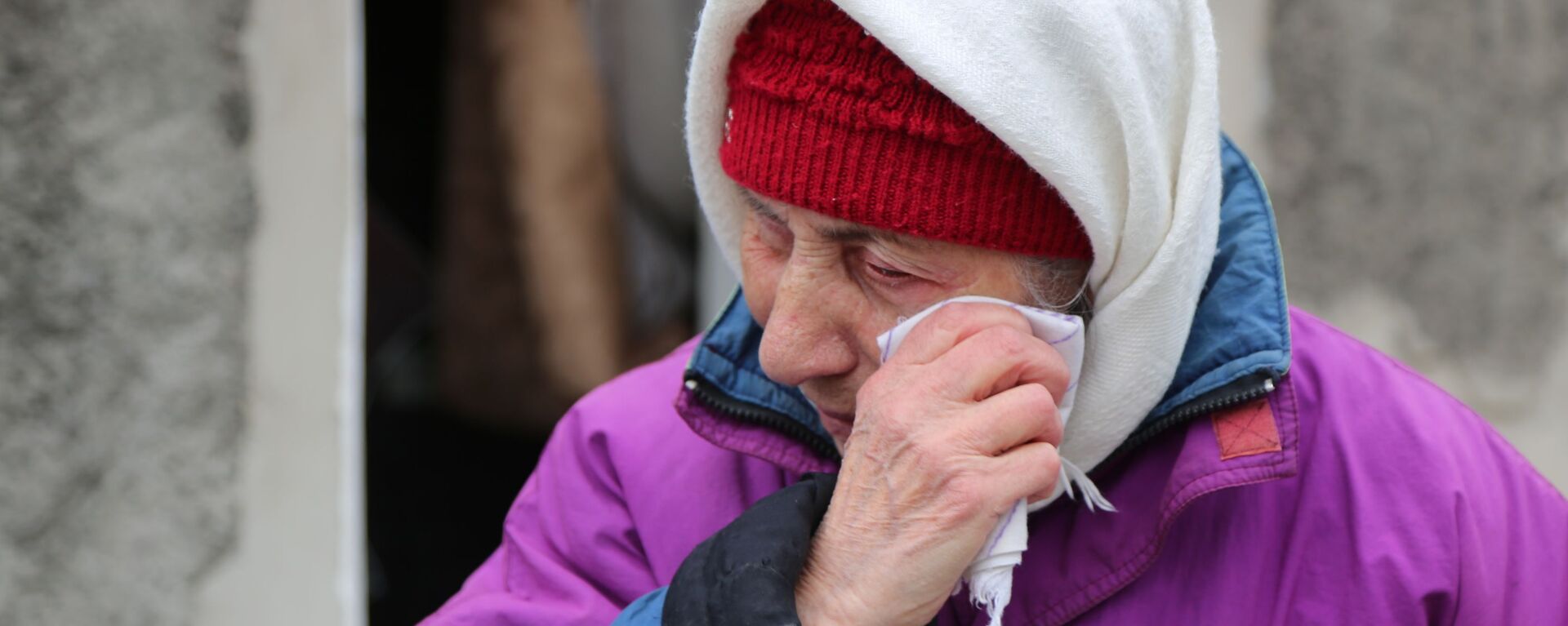 Пожилая женщина плачет около жилого дома в Киевском районе Донецка, разрушенном в результате обстрела - Sputnik Latvija, 1920, 17.03.2022