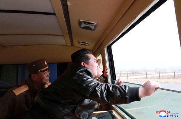 Северокорейский лидер Ким Чен Ын смотрит в окно во время испытательных пусков ракеты. - Sputnik Латвия