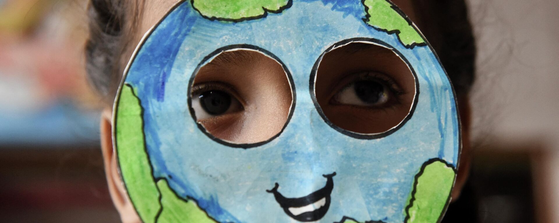 Ученик надевает маску, сделанную в форме планеты Земля, во время мероприятия по случаю Дня Земли в школе в Амритсаре, Индия - Sputnik Латвия, 1920, 03.08.2022