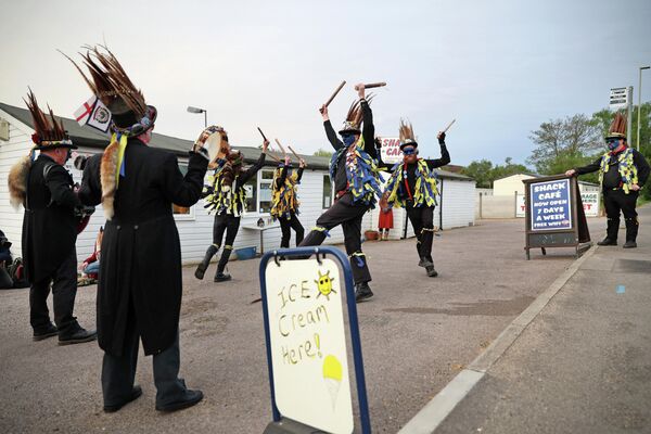 Участники Hook Eagle Morris танцуют перед кафе Shack на рассвете, чтобы отпраздновать Первомай в деревне Хук, западнее Лондона, 1 мая 2022 года. - Sputnik Латвия