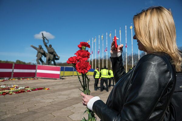 Meitene nofotografēja piemiņai sarkanās neļķes Uzvaras pieminekļa fonā - Sputnik Latvija