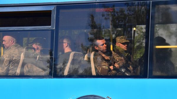 Автобус со сдавшимися в плен украинскими военнослужащими и боевиками националистического батальона Азов выезжает с территории завода Азовсталь в Мариуполе - Sputnik Латвия
