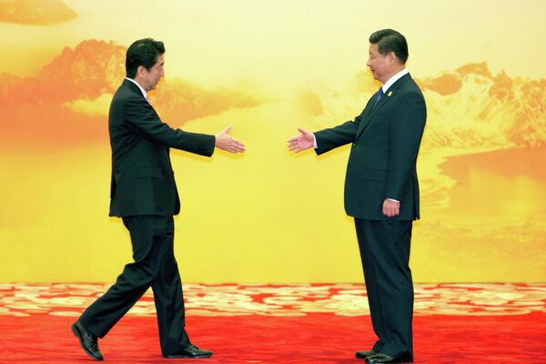 Премьер-министр Японии Синдзо Абэ и председатель КНР Си Цзиньпин во время встречи экономических лидеров Азиатско-Тихоокеанского экономического сотрудничества (АТЭС), Пекин, 11 ноября 2014 г. - Sputnik Латвия
