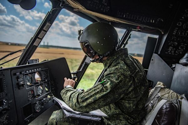 Военный летчик в кабине вертолета Ми-8МТВ на полевом аэродроме - Sputnik Латвия