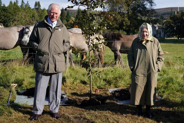 Королева Елизавета II и принц Чарльз рядом с деревом, которое они посадили в поместье Балморал в Шотландии, 1 октября 2021 года. - Sputnik Латвия