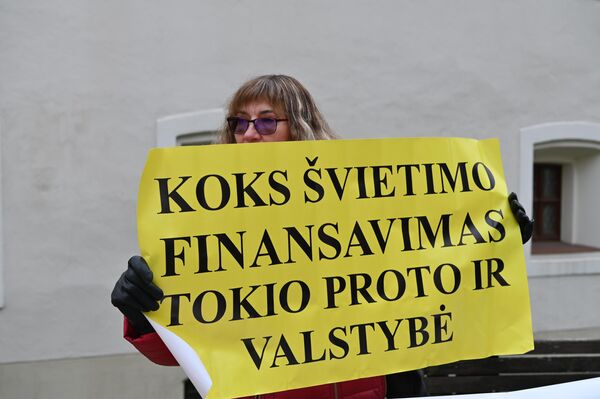 Участница акции протеста держит плакат с надписью: &quot;Какое финансирование образования, такого ума и государство&quot;. - Sputnik Латвия