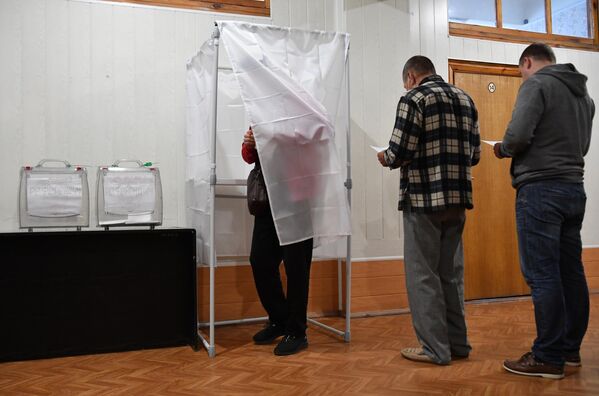 Люди голосуют на референдуме о присоединении Запорожской области к России на избирательном участке на мелитопольском предприятии. - Sputnik Латвия
