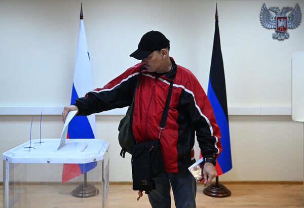 Мужчина голосует на референдуме на избирательном участке в посольстве ДНР в Москве - Sputnik Латвия