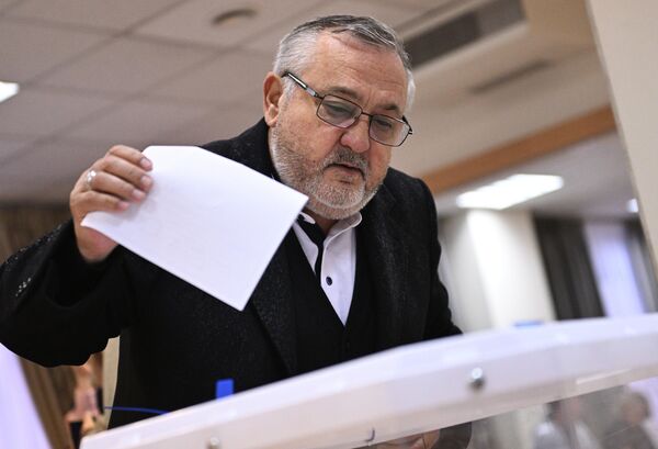 Мужчина голосует на референдуме на избирательном участке в посольстве ДНР в Москве - Sputnik Латвия
