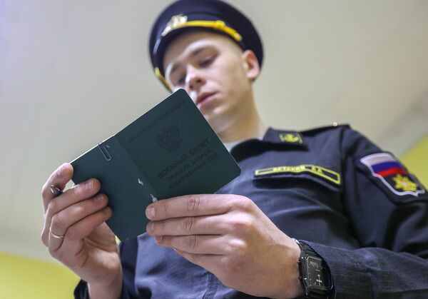 Сотрудник военного комиссариата в Мурманске изучает военный билет офицера запаса ВС - Sputnik Латвия