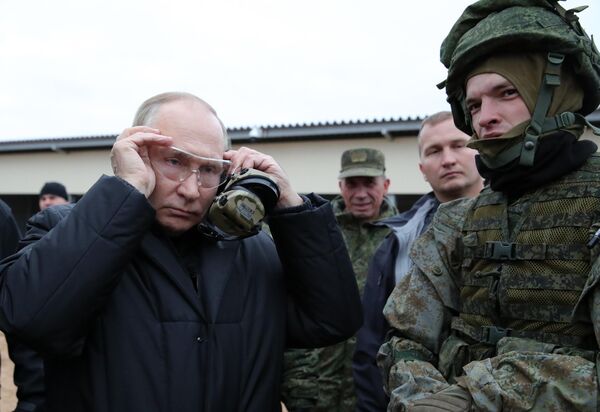 Путин, надев защитные очки и наушники, сам сделал несколько тестовых выстрелов по мишени. - Sputnik Латвия